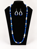 Royal blue and white beaded necklace with matching earrings on black jewelry display