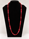 Red crystal and textured beaded statement necklace on black jewelry display